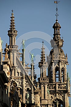 Magnificent high-rise building featuring ornate towers and statues in Brussels against a blue sky