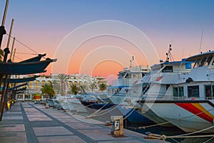 Magnificent magenta sunset color in marina harbor. End of a warm sunny day in Ibiza, St Antoni de Portmany, Spain.