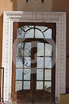 A magnificent old double door with glass inserted in the frames.