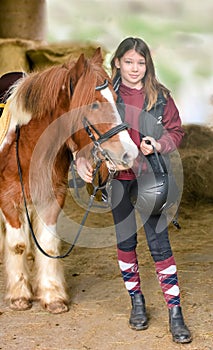 Magnificent portrait of a young girl and her pony with her riding helmet and protective vest,