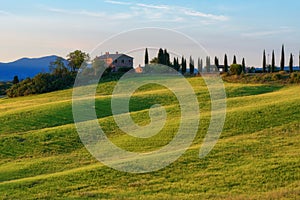Magnificent spring landscape at sunrise.Beautiful view of typical tuscan farm house, green wave hills.