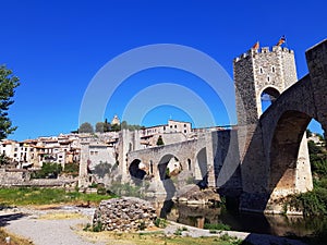 Magnificent stone arched  romanic bridge in Besalu. General beautiful view of Besalu village. Beautiful sunny day