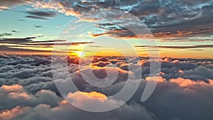 Magnificent sunrise on dense clouds. Aerial view of sun rises from behind the clouds starting a new day. Rising sun