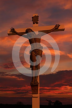 Magnificent sunset behind lifesize cross with body of Jesus