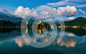 Magnificent view of Bled lake and illuminated pilgrimage church on island at twilight reflected in water, Slovenia