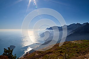 Magnificent view of the mountain at sunset sun-lit bay. Calm sea and mountains in a light haze in Antalya in Turkey