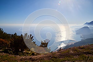 Magnificent view of the mountain at sunset sun-lit bay. Calm sea and mountains in a light haze in Antalya in Turkey