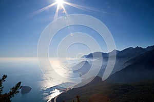 Magnificent view of the mountain at sunset sun-lit bay. Calm sea and mountains in a light haze in Antalya in Turkey