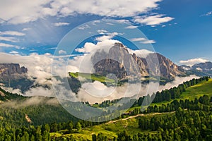 Magnificent view of Sassolungo massif and Gardena valley covered by white clouds, Dolomites, Italy