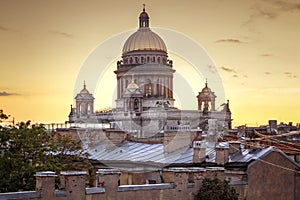 A magnificent view of St. Isaac`s Cathedral at sunset from the rooftops. Top view of the city of St. Petersburg. Beautiful sunset