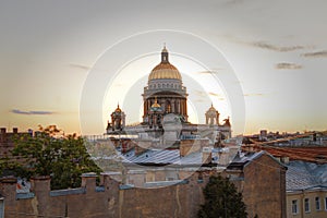 A magnificent view of St. Isaac`s Cathedral at sunset from the rooftops. Top view of the city of St. Petersburg. Beautiful sunset
