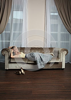 Magnificient woman resting on brown sofa indoor