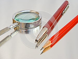 Magnifier, biro and pencil.