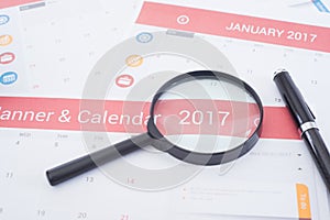 Magnifier and business Calender Planner 2017 on desk office.