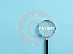 Magnifier focuses on the word patent. Concept of patenting or copyright protection