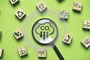 Magnifier glass with CO2 reduction and environment icons for decrease CO2 , carbon footprint and carbon credit to limit global