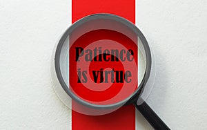 Magnifier with text Patience is virtue on the white and red background