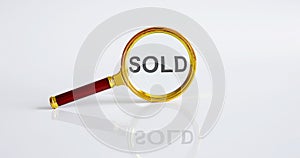 Magnifier with text SOLD on the white background