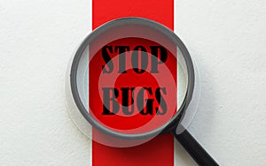 Magnifier with text Stop Bugs on the white and red background
