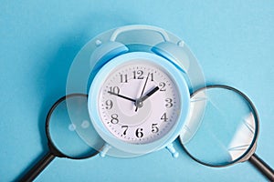 magnifiers and alarm clock on a blue background