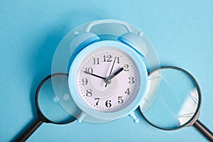 magnifiers and alarm clock on a blue background photo