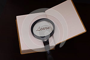 Magnifing glass on a book to help facilitate the vision for reading and to learn