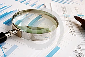 Magnifying glass for audit and stack of reports photo