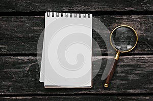 Magnifying glass and blank page note pad.
