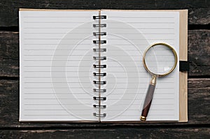Magnifying glass and blank page note pad.