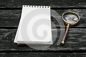 Magnifying glass and blank page note pad.