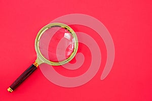 Magnifying glass on a bright red background