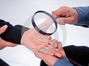 Magnifying glass on business man hand
