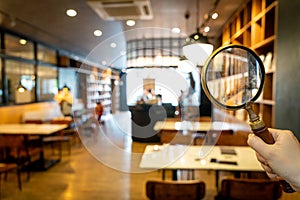 Magnifying glass with cafe restaurant with abstract blur cafe restaurant for background