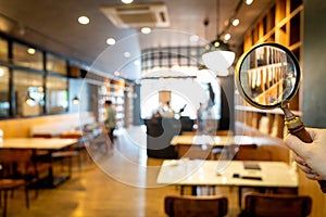 Magnifying glass with cafe restaurant with abstract blur cafe restaurant for background