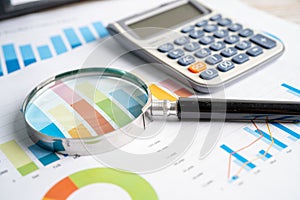 Magnifying glass and calculator on charts graphs paper. Financial development, Banking Account, Statistics, Investment Analytic