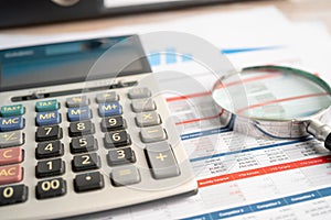 Magnifying glass and calculator on charts graphs paper. Financial development, Banking Account, Statistics, Investment Analytic