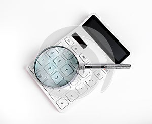 Magnifying glass at calculator. Financial report, statistical data analysis concept. Accountant or auditor job. Balance