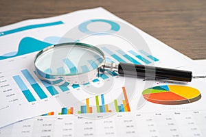 Magnifying glass on charts graphs paper. Financial development, Banking Account, Statistics, Investment Analytic research data