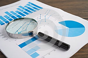 Magnifying glass on charts graphs paper. Financial development, Banking Account, Statistics, Investment Analytic research data