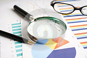 Magnifying glass on charts graphs paper. Financial development, Banking Account, Statistics, Investment Analytic research data