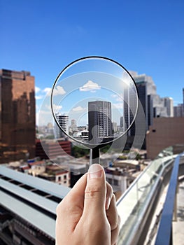 Magnifying glass and cityscape in focus