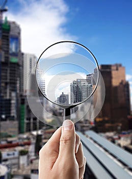 Magnifying glass and cityscape in focus