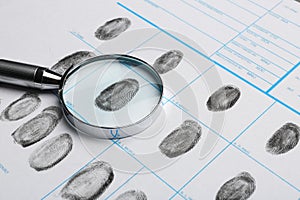 Magnifying glass and criminal fingerprint card