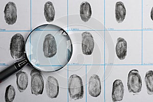 Magnifying glass and criminal fingerprint card