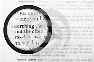 Magnifying glass and dictionary definition of the word searching