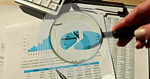 Magnifying glass focusing on diagram and analytical report