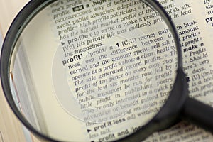 Magnifying glass focusing on profit word