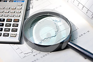 A magnifying glass focusing on stock chart