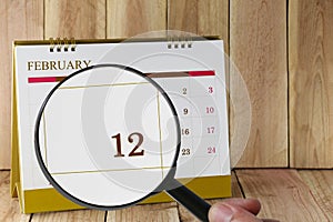 Magnifying glass in hand on calendar you can look twelfth day of photo