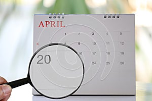 Magnifying glass in hand on calendar you can look Twentieth day